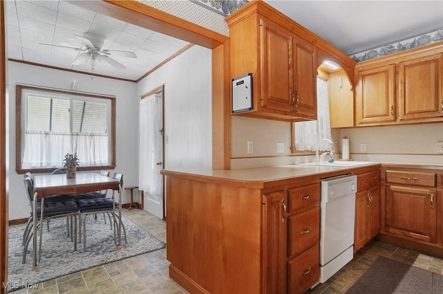 kitchen with baseboards, light countertops, ornamental molding, white dishwasher, and a sink