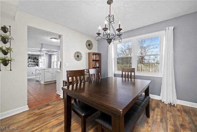 dining space with dark wood-style floors, baseboards, and a textured ceiling