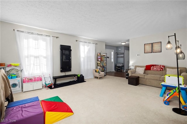 recreation room featuring a textured ceiling and carpet