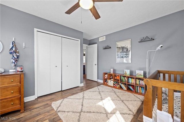 bedroom with a closet, baseboards, visible vents, and wood finished floors