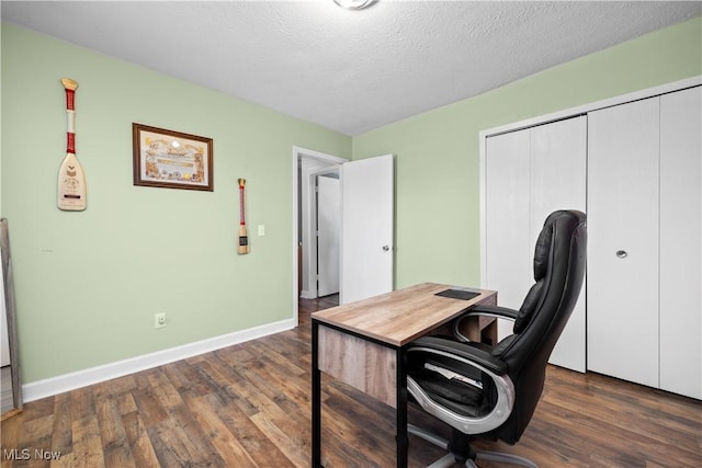 office space featuring baseboards, dark wood-style flooring, and a textured ceiling