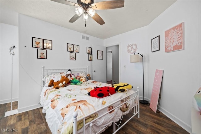 bedroom with visible vents, baseboards, wood finished floors, and a ceiling fan