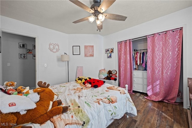 bedroom featuring dark wood-style floors, a textured ceiling, and ceiling fan