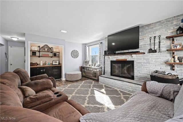 living area with a fireplace, baseboards, and wood finished floors