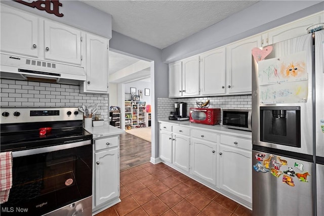 kitchen with under cabinet range hood, white cabinetry, appliances with stainless steel finishes, and light countertops