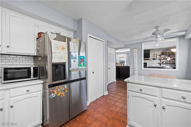 kitchen with tile patterned floors, stainless steel refrigerator with ice dispenser, a textured ceiling, white cabinets, and light countertops