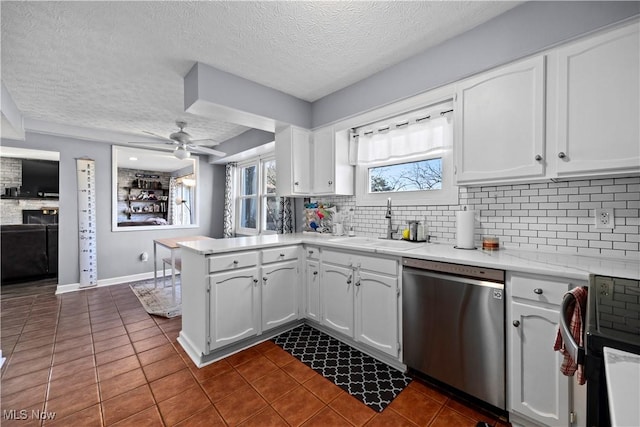 kitchen with a sink, white cabinetry, a peninsula, decorative backsplash, and dishwasher