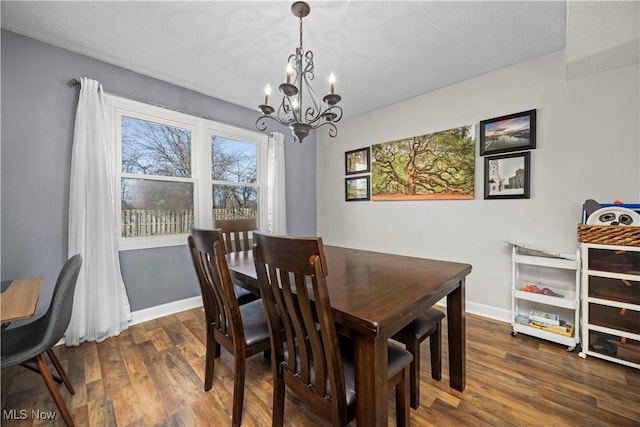 dining area with a chandelier, baseboards, and wood finished floors