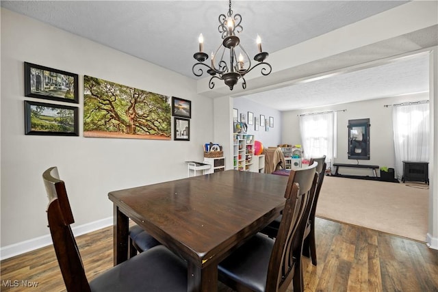 dining space with wood finished floors, baseboards, and a textured ceiling