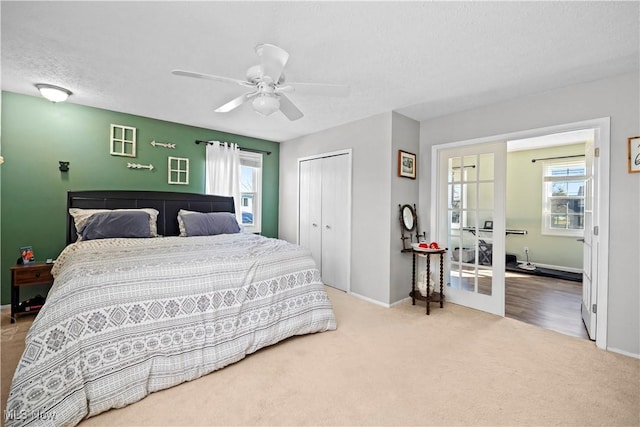 carpeted bedroom featuring baseboards, a ceiling fan, a closet, and a textured ceiling