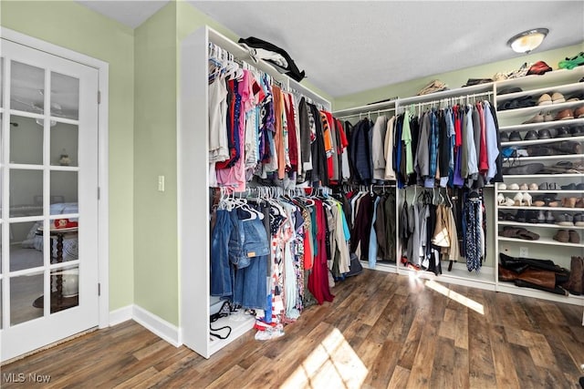 walk in closet with wood finished floors