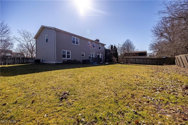 back of house with a lawn, central AC unit, and a fenced backyard