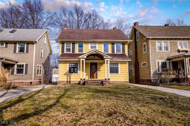 view of front of house with a front yard, an outbuilding, and driveway