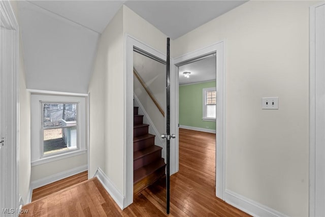 stairway with wood finished floors and baseboards