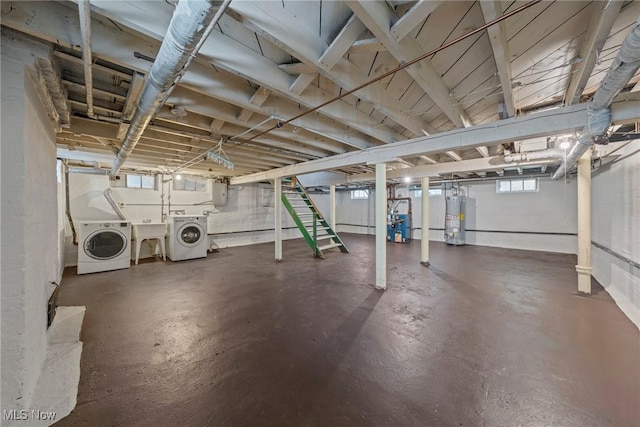 below grade area featuring gas water heater, stairway, electric panel, and washer and clothes dryer