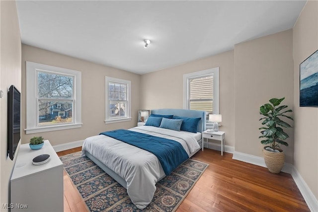 bedroom with baseboards and wood finished floors