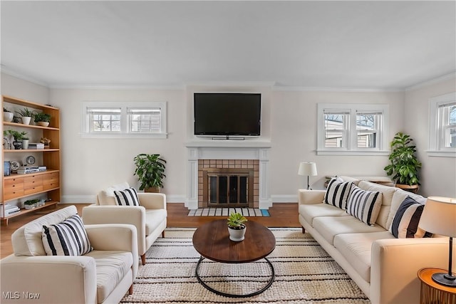 living area with a tiled fireplace, wood finished floors, and ornamental molding