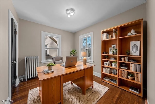 office space featuring radiator heating unit, baseboards, and dark wood-style flooring