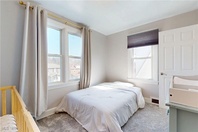 carpeted bedroom featuring baseboards, multiple windows, and visible vents