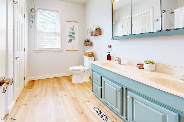 full bathroom featuring double vanity, visible vents, wood finished floors, and a sink