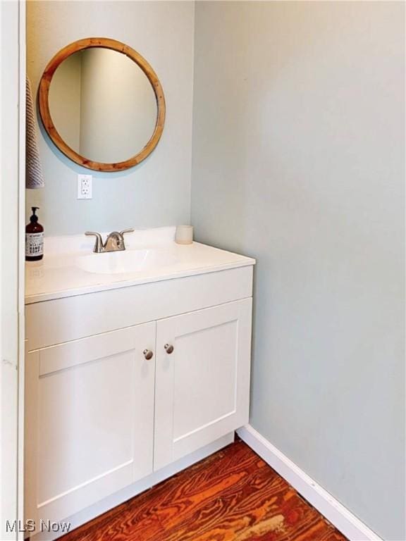 bathroom featuring vanity, baseboards, and wood finished floors