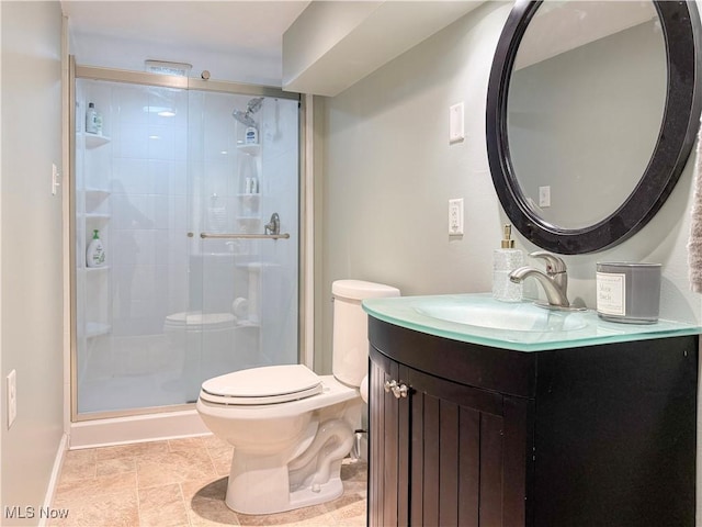 bathroom featuring baseboards, toilet, a stall shower, and vanity