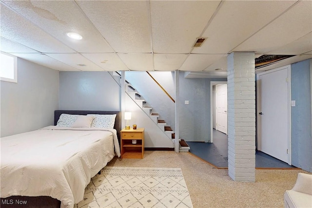 bedroom with a paneled ceiling and carpet floors