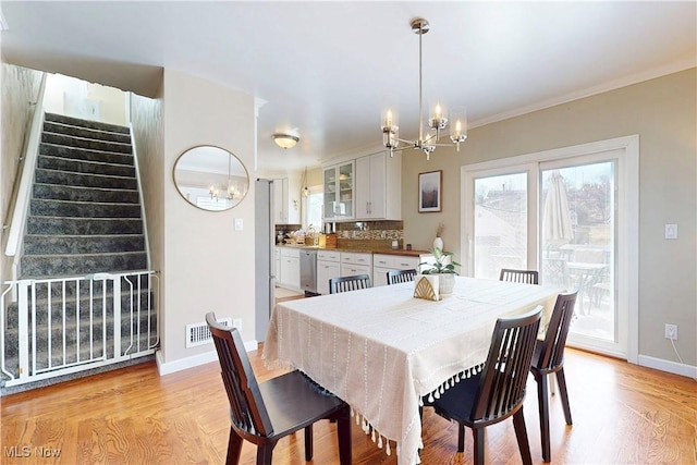 dining room with stairway, a wealth of natural light, and a chandelier