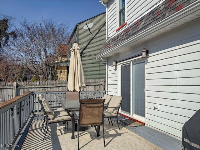 deck with outdoor dining space and fence