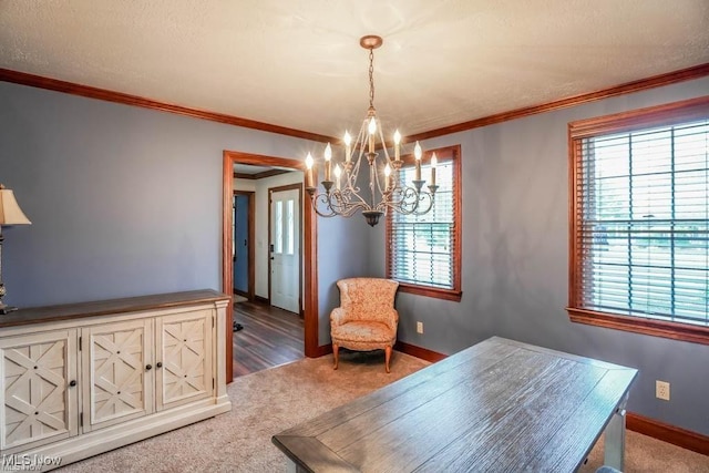 carpeted dining space with a textured ceiling, baseboards, and ornamental molding