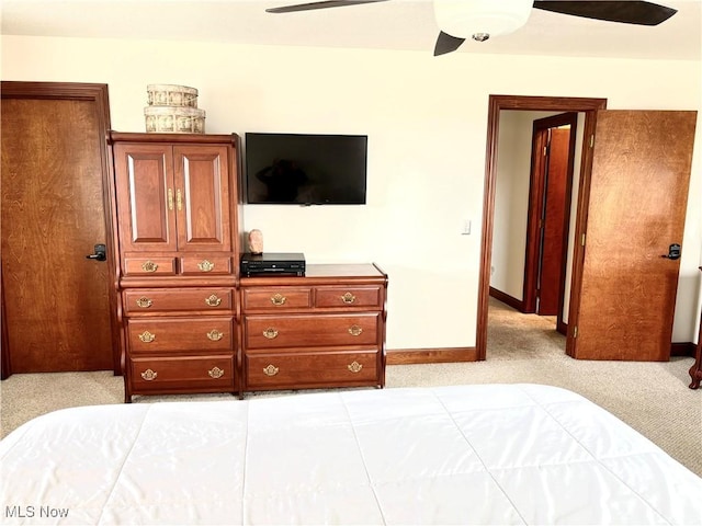 bedroom with light colored carpet, baseboards, and ceiling fan