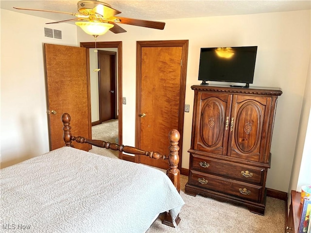 bedroom featuring light carpet, visible vents, baseboards, and a ceiling fan