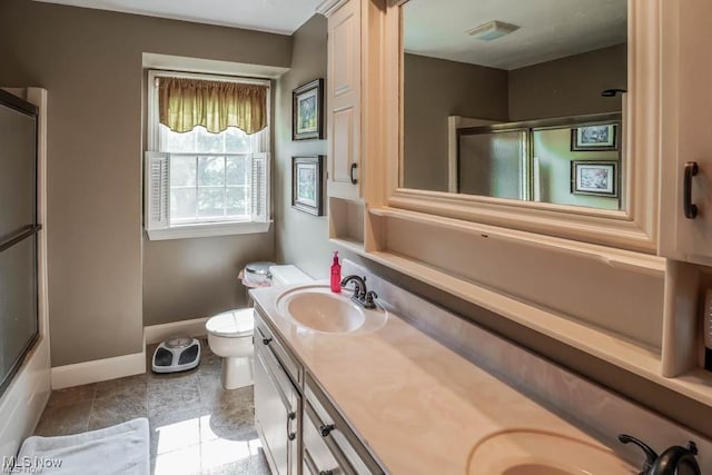 bathroom with double vanity, visible vents, toilet, and a sink