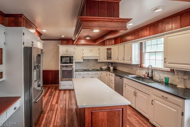 kitchen featuring a center island, wood finished floors, black appliances, and a sink