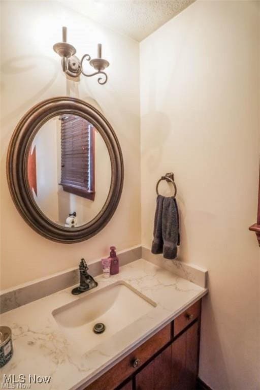 bathroom with a textured ceiling and vanity