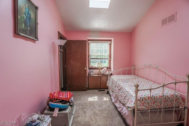 bedroom with a skylight, visible vents, and carpet floors