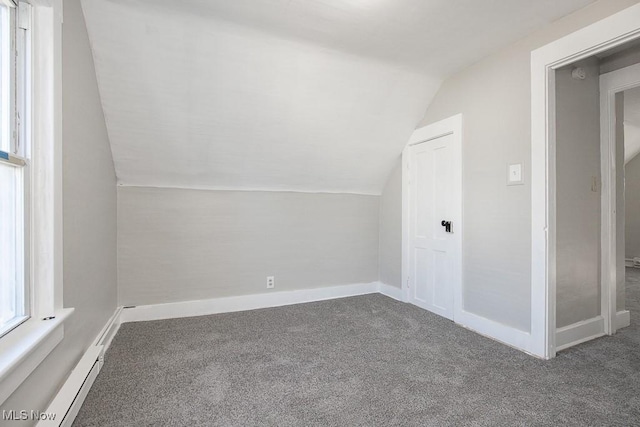 additional living space featuring vaulted ceiling, carpet flooring, baseboards, and a baseboard radiator