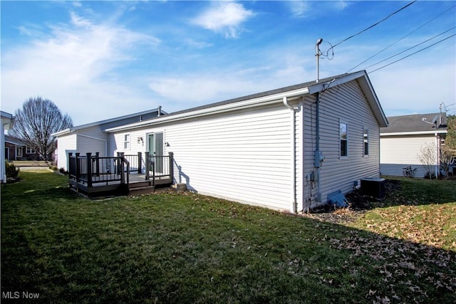 rear view of house with central air condition unit, a yard, and a wooden deck