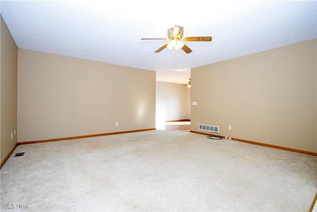 carpeted empty room with visible vents, baseboards, and a ceiling fan