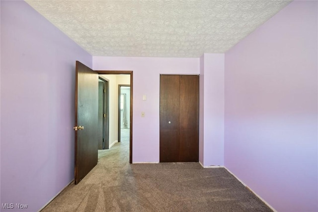 unfurnished bedroom with a closet, a textured ceiling, and carpet