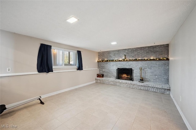 unfurnished living room featuring tile patterned floors, a fireplace, a textured ceiling, and baseboards