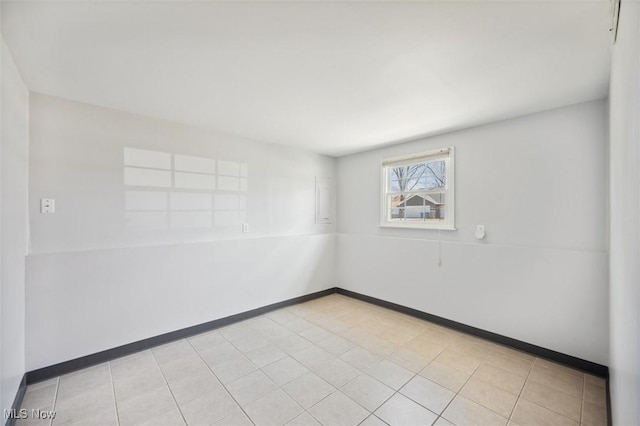 spare room with light tile patterned floors and baseboards