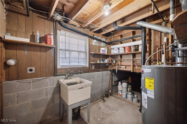 basement featuring concrete block wall and water heater