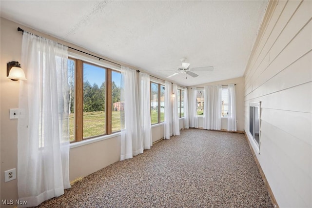 unfurnished sunroom with ceiling fan