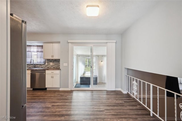 kitchen featuring backsplash, white cabinets, dishwasher, and dark wood-type flooring