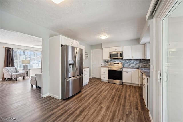 kitchen with decorative backsplash, white cabinets, stainless steel appliances, and dark wood-type flooring