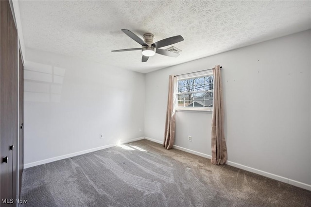 spare room featuring visible vents, a ceiling fan, a textured ceiling, carpet floors, and baseboards