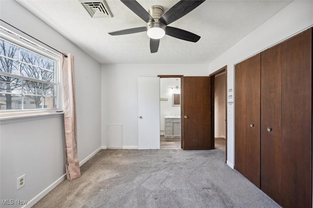 unfurnished bedroom featuring baseboards, visible vents, carpet floors, a closet, and a textured ceiling