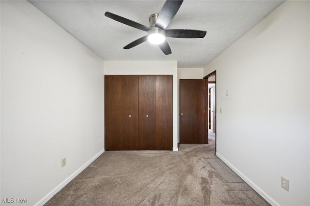 unfurnished bedroom featuring a closet, baseboards, carpet, and a textured ceiling