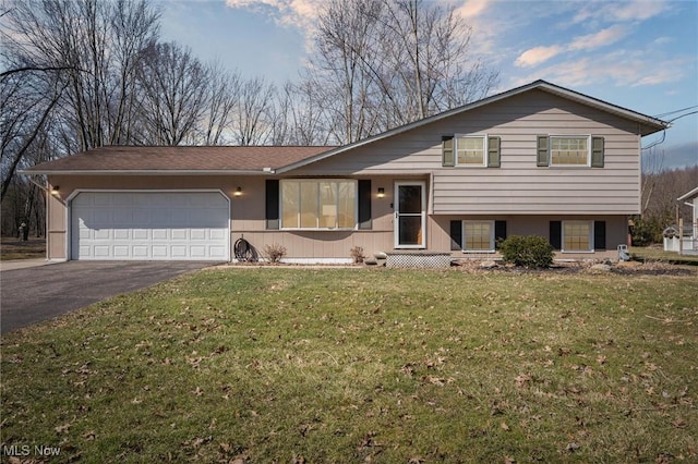 split level home with a front lawn, a garage, and driveway